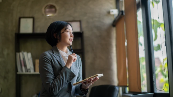 woman holding notebook and thinking