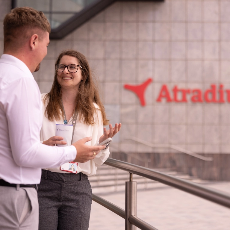 Woman and man have coffee break outside at the entrance of the Cardiff office
