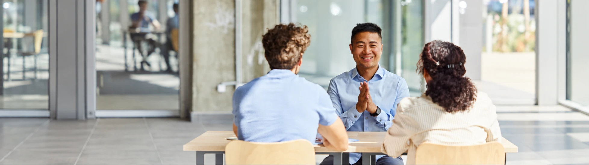 3 people talking at desk