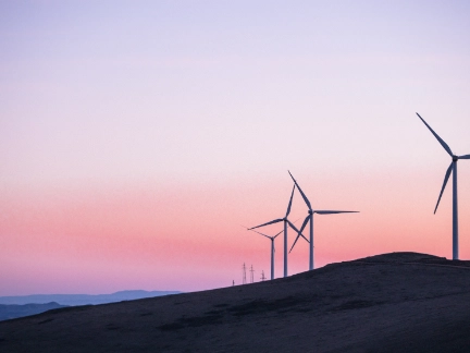 Wind turbines on a hillside at dusk